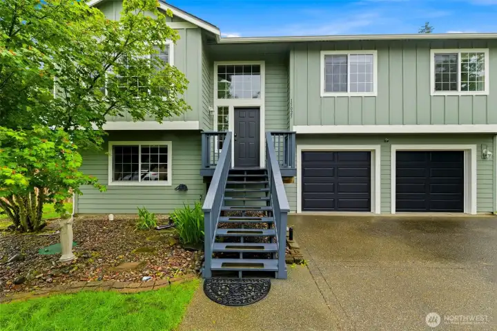 A welcoming staircase leads to the front door, while the attached two-car garage offers plenty of room for vehicles, hobbies, and extra storage. A welcoming staircase leads to the front door, while the attached two-car garage offers plenty of room for vehicles, hobbies, and extra storage.