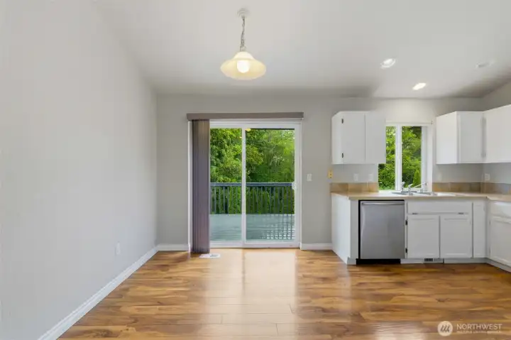 Dining area with direct deck access and serene backyard views Dining area with direct deck access and serene backyard views