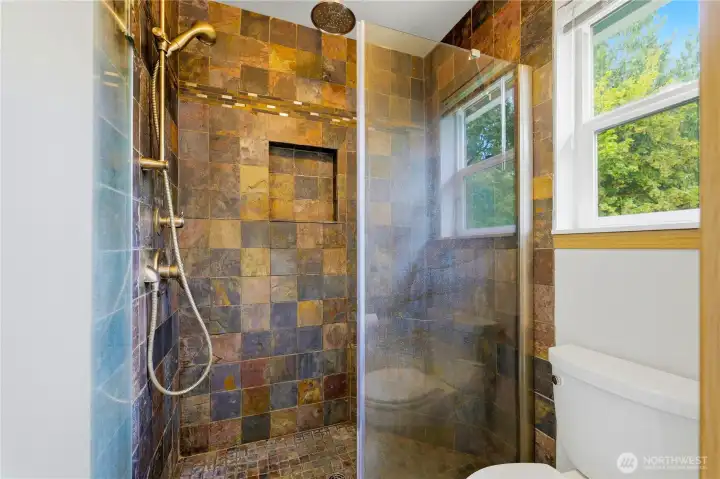 Spa-inspired primary bathroom featuring a beautifully tiled walk-in shower with glass enclosure Spa-inspired primary bathroom featuring a beautifully tiled walk-in shower with glass enclosure