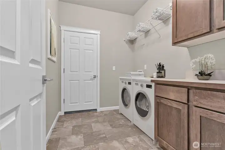 Laundry room with shaker cabinets and ceramic tile floor. Laundry room with shaker cabinets and ceramic tile floor.