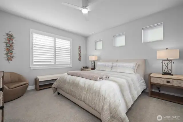 Primary bedroom with transom windows, black out shade, and plantation shutters
