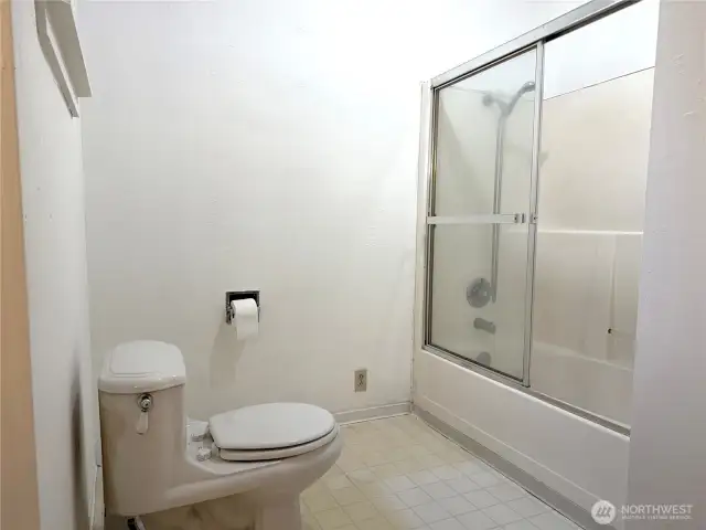Large bathroom with natural light, glass shower door
