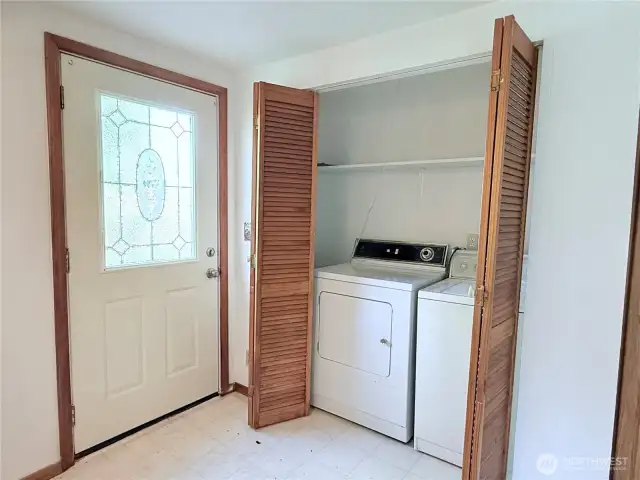 Older working washer and dryer by back door