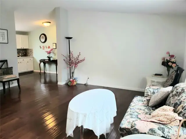 A Different View of the Living Room greets you as you walk in from the Front Door to This Beautiful Home Showing the Eating Area, Hard Wood Flooring, and Newer Paint and Trim.