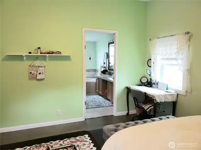 An Opposite View of the Spacious Primary Master Bedroom Showing Hard Wood Flooring Showing Room for King Sized Bed and Room for Dressers Looking into the Primary Bathroom.
