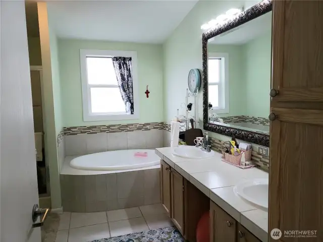 A View of the 5 Piece Primary Master Bathroom Showing Tile Counter Top, Tile Floor, and Tile Soaking Tub Surround.