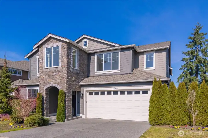 Front of home with arched stone-accent entry.