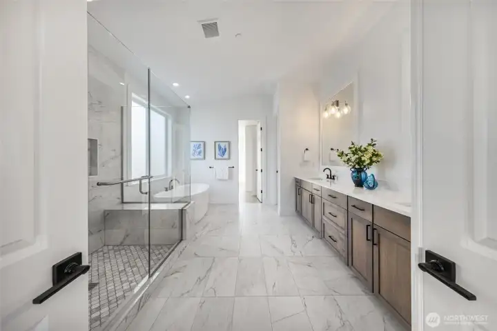 Luxurious primary bath with in-floor heating, large walk-in shower with double shower heads, and double-vanity.