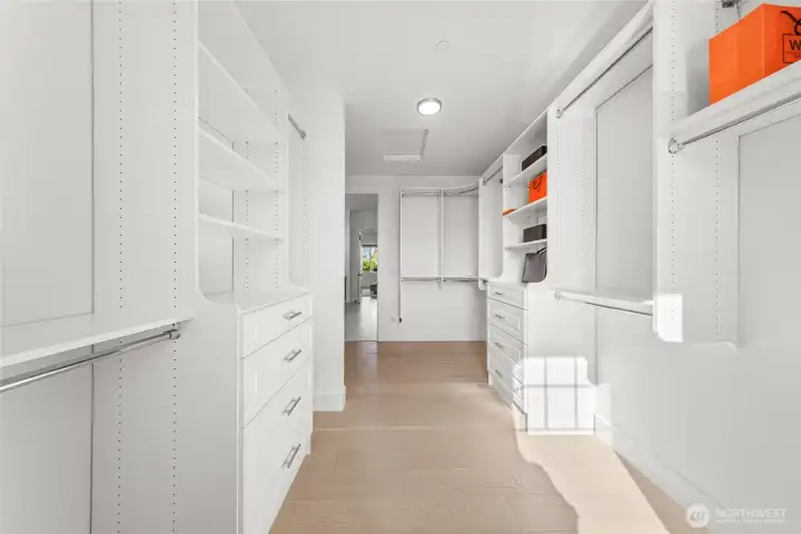 Huge walk-in closet with built in shelves and drawers off the primary bath.