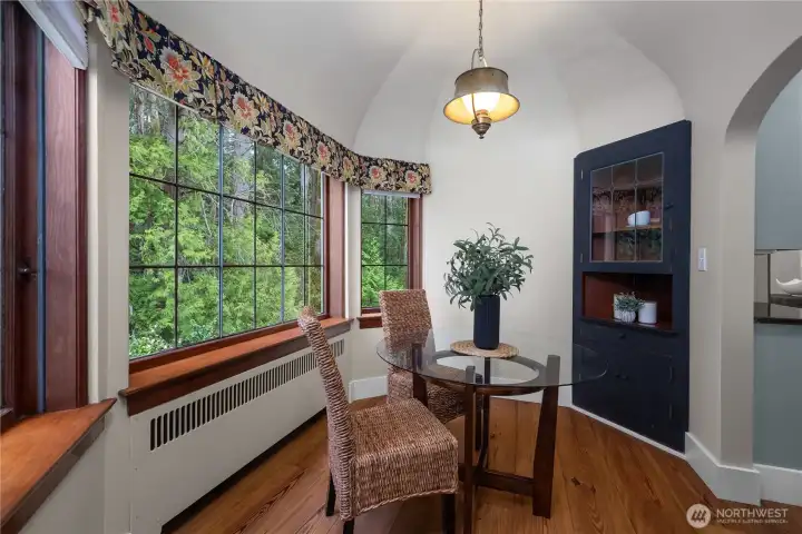 A light-filled nook with beautifully maintained architectural detail offers a warm and intimate everyday dining space.