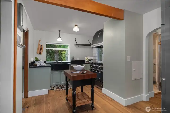 Rich wood flooring, soapstone counters and sink, and a professional-grade gas range/dual fuel oven bring timeless function to this beautifully maintained kitchen.