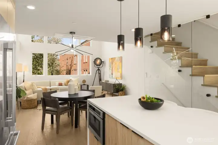 The high-design aesthetic is anchored by a luxury glass-walled staircase.