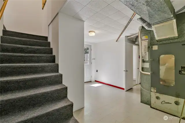 Staircase leading to large basement from the kitchen. Notice the door to backyard on the back wall & the basement bathroom on the right.