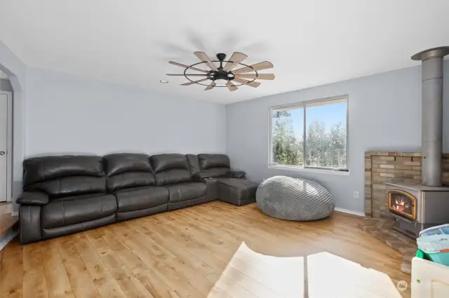 Cozy living room with wood burning stove and upgraded living room ceiling fan.