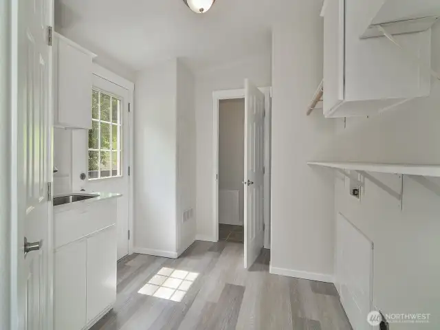 Large laundry and mud room with storage off the kitchen.
