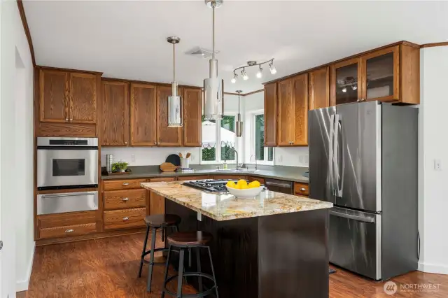 Gourmet kitchen w/ granite & corian countertops, gas range, SS appliances & breakfast bar island