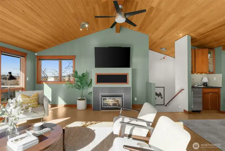 Cedar vaulted ceilings, expansive windows, and a cozy gas fireplace add character and comfort, while modern mini-splits provide efficient year-round AC.