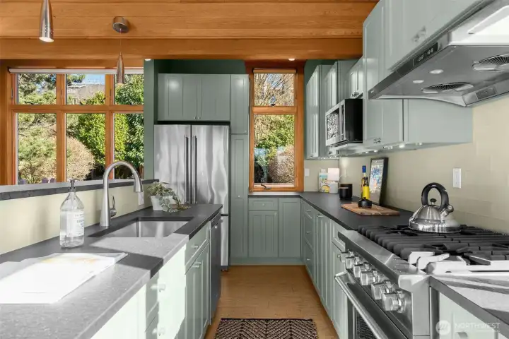 The chef’s kitchen features stainless appliances, a gas range, bar seating, and refined finishes.