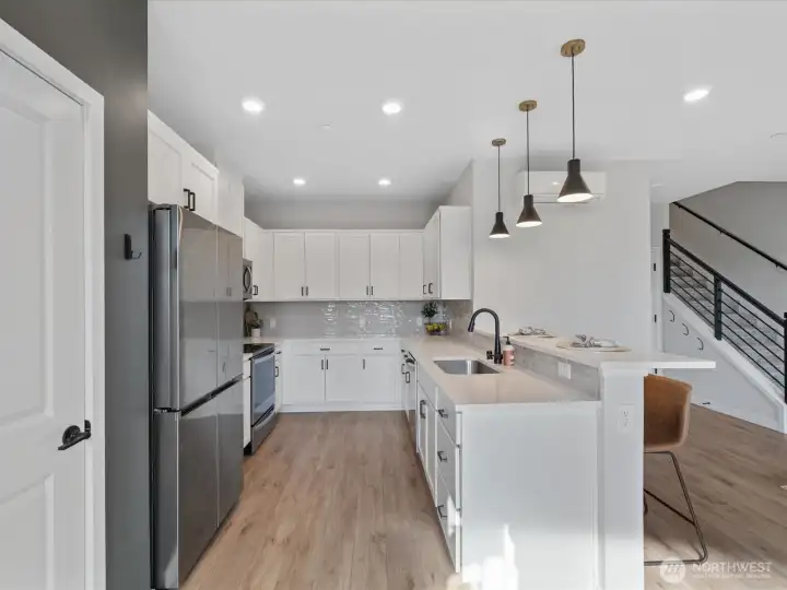 Well appointed kitchen with ample cabinets, quartz counters and stainless steel appliances.