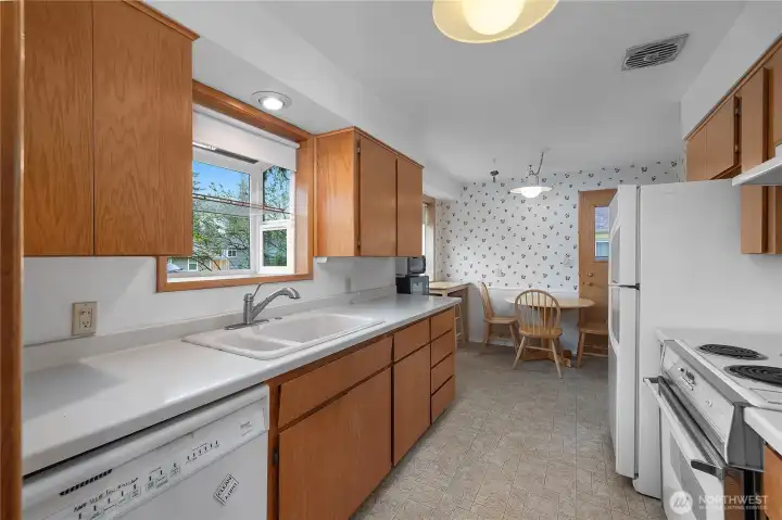 Functional kitchen with ample cabinetry, generous counter space, and adjacent dining area.