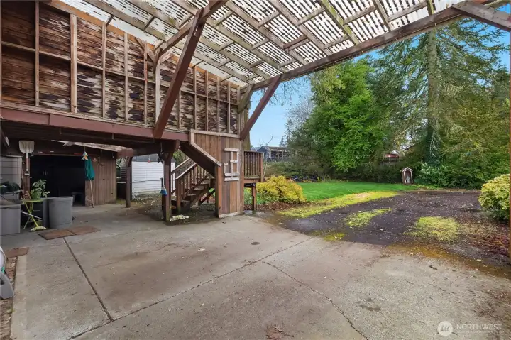 Covered patio and stair access connect the home to the spacious backyard.