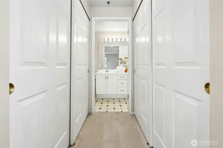 Hallway with dual closets and access to bedrooms and bath.