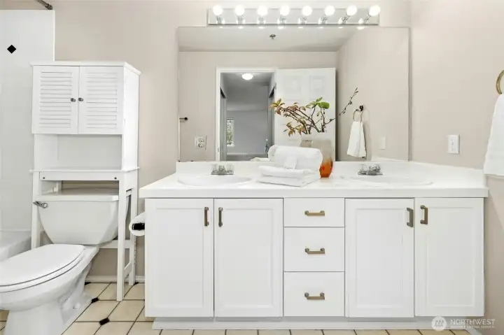 Bathroom with double vanity and ample storage.