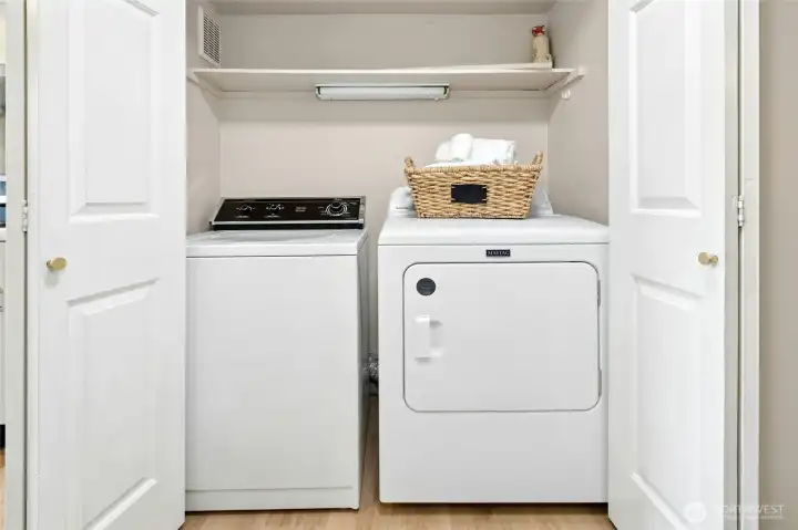 Laundry area with washer and dryer and built-in shelving.