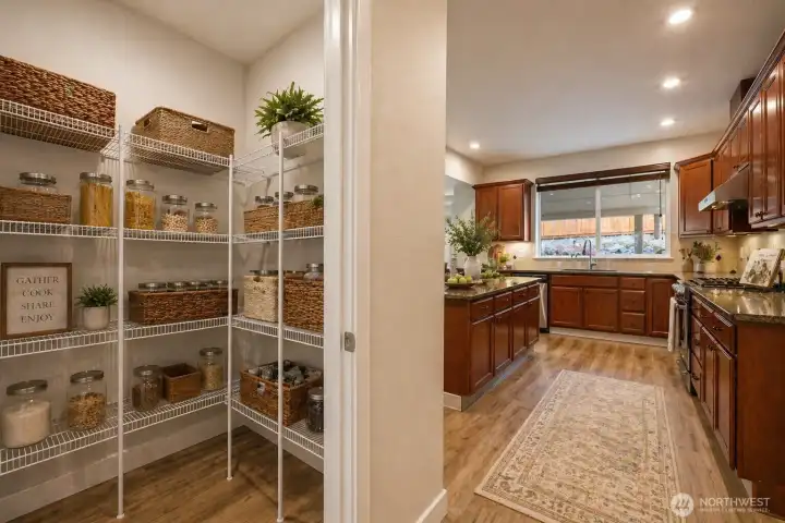 Adjacent to the kitchen, an oversized walk-in pantry features floor-to-ceiling shelving, offering exceptional storage and organization to keep everything easily accessible. Thoughtfully designed for both everyday living and effortless entertaining, this kitchen and pantry combination delivers the perfect blend of convenience, functionality, and style.