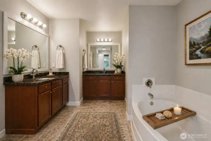 Luxurious primary bathroom featuring rich dark wood cabinetry, dark granite counters, dual vanities, and a relaxing soaking tub. Adjacent is an enormous walk-in closet with premium custom wood shelving, offering abundant organized storage and a boutique-level dressing experience. Sophisticated, spacious, and serene.