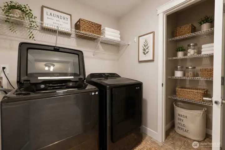 Perfectly positioned on the bedroom level, this bright and highly functional laundry room makes chores effortless. No more lugging baskets up and down stairs! It features a full-size Samsung top-load washer and matching dryer, abundant shelving, and a multi-tier pantry-style closet for superior storage. Clean lines, neutral tones, and stylish staging create a welcoming space that combines practicality with charm.