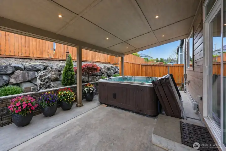 Step into your own private outdoor retreat featuring a luxurious jacuzzi beneath a spacious covered gazebo, perfect for year-round relaxation and entertaining. The thoughtfully designed low-maintenance yard offers beautiful rock landscaping, lush greenery, and dedicated garden space for flowers, herbs, or seasonal plantings. Extensive concrete walkways wrap around the home, creating clean lines, easy accessibility, and seamless indoor-outdoor flow. Whether enjoying a peaceful evening soak, hosting guests under the covered patio, or simply admiring the serene surroundings, this backyard delivers the perfect blend of comfort, functionality, and resort-style living.