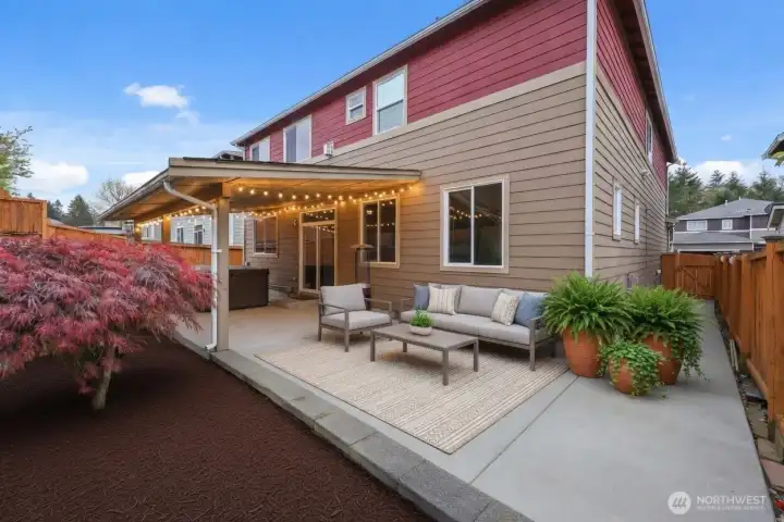 Discover your private outdoor paradise! This stunning, low-maintenance backyard delivers expansive concrete patios and walkways that create effortless elegance and year-round usability. A massive covered porch/gazebo area provides generous sheltered space for dining, lounging, or entertaining, while the luxurious Jacuzzi invites you to unwind beneath the stars.  Beautifully designed with dedicated garden beds ready for your personal touch, the fully fenced yard offers privacy and tranquility in a low-upkeep setting. Thoughtfully planned with abundant hardscaping, this dramatic outdoor retreat is perfect for effortless living, memorable gatherings, and relaxing escapes — all just steps from your door