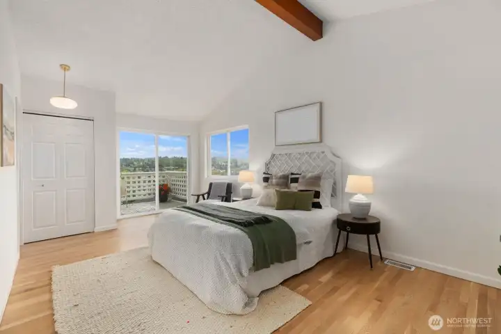 Primary bedroom with vaulted ceilings, balcony facing west