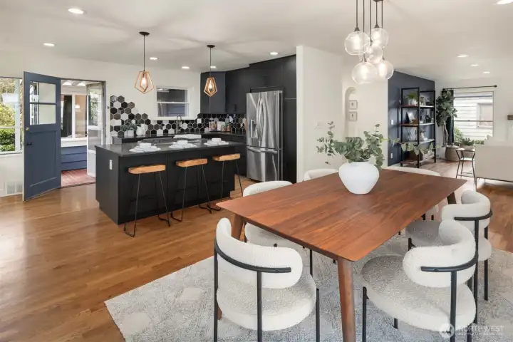The spacious open-concept kitchen showcases striking black countertops, custom tile, and clean, modern finishes designed for both everyday living and effortless entertaining.