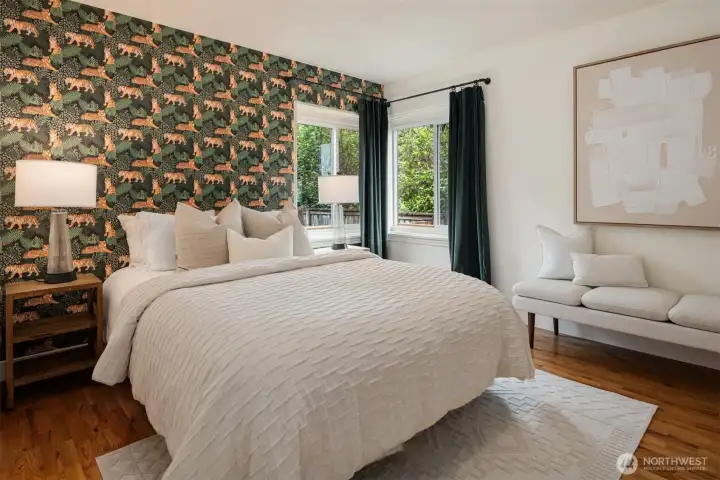 Located in the northwest corner of the home, this charming third main-floor bedroom is enhanced by custom wallpaper that adds warmth, character, and timeless style.