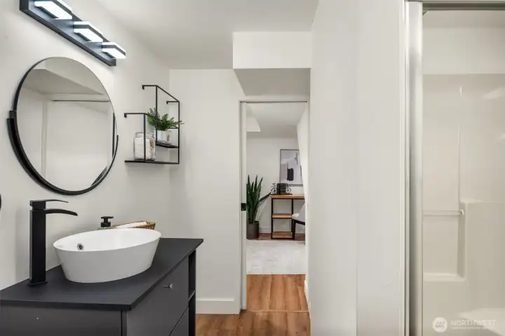 The thoughtfully appointed lower-level three-quarter bathroom offers comfort and convenience for guests and everyday living alike.