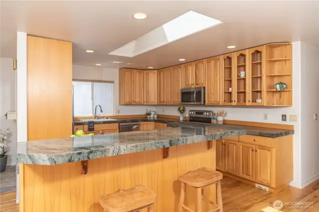 Thick granite counter tops, raised bar, ample storage, Hardwood flooring and stainless appliances grace this lovely kitchen!