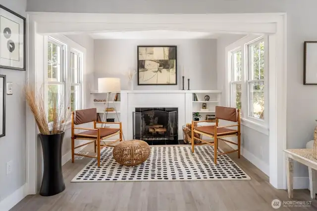 Sun-kissed study nook with cozy wood fireplace and built-in bookshelf, a perfect area for reading or unwinding.