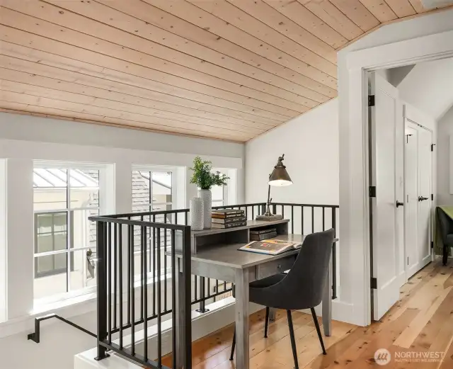 At the top of the stairs, a landing accommodates a work from home space or a spot to curl up with a good book.