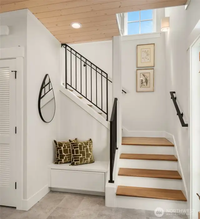 Gracious open stairway entry is graced with custom metal railings.
