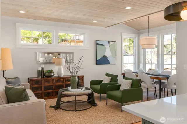 The light filled living room is surrounded by windows to let in light.
