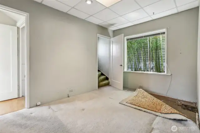 This room has been used as an office.  Appears to be original Marmoleum under carpets. Stairs go to upper bedrooms.