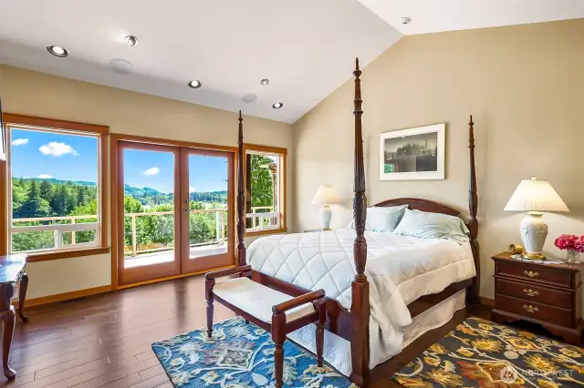 Primary bedroom with French doors, scenic view and vaulted ceilings