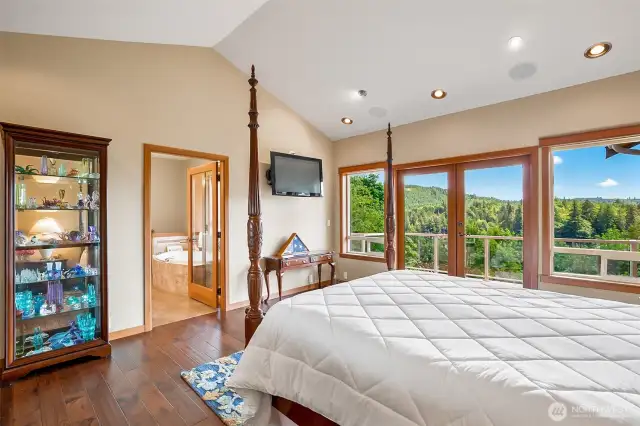 Primary bedroom with French doors, scenic view and vaulted ceilings