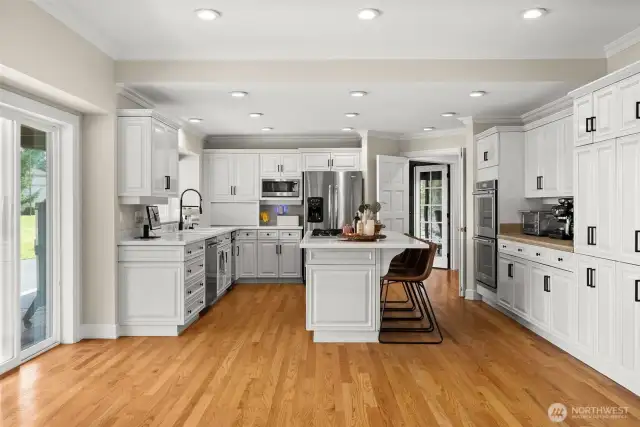 Chef's kitchen features new hardware and stainless steel appliances. Quartz countertops paired with tile countertops for the appliance bar.