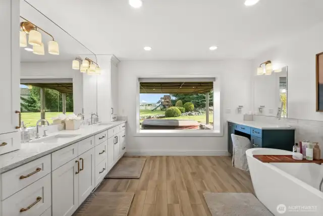 Tastefully remodeled primary bathroom: New vanities, tile flooring, bathtub, light fixtures, mirrors, tile shower and reconfigured layout.