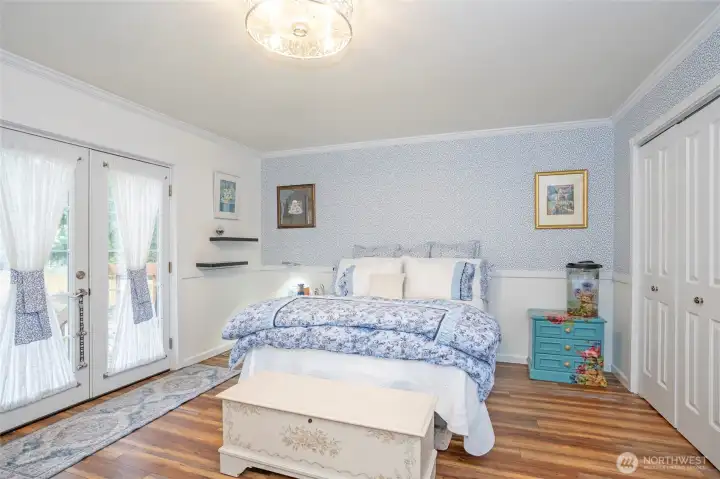Primary suite with access to a private deck through elegant French doors.