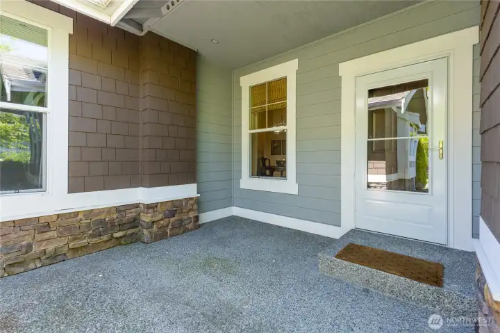 Charming covered front porch features beautiful stone accents and a welcoming entry to the home.