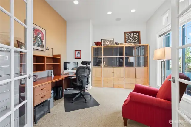 Off the entry is the handsome office/den with double glass doors and an attached display and storage cabinet.